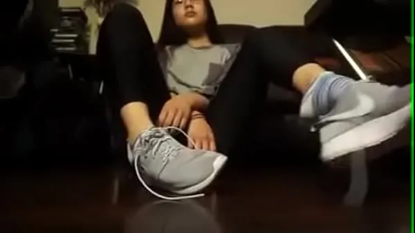 แสดง Asian girl takes off her tennis shoes and socks หลอดอุ่น