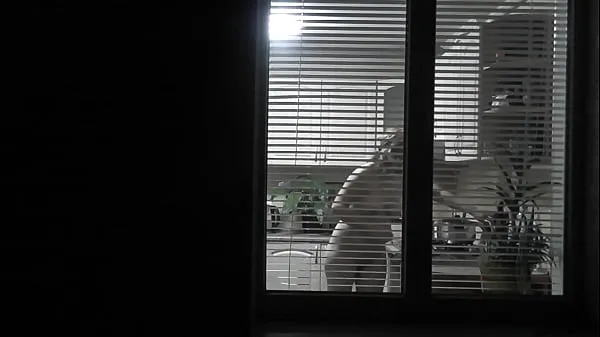 Mostrar espiando Voyeur. Un vecino voyeur pervertido por la noche en la calle mira por la ventana mientras un vecino desnudo y sexy en la cocina prepara la cena para su marido. Desnudo en público. Desnuda en casa. Familia. Exteriortubo caliente